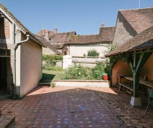 a courtyard with a bench and a building at La Maison Pieuse in Villiers-Saint-Benoît