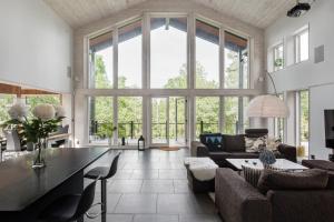 Modern holiday home in Kisa في Kisa: غرفة معيشة كبيرة مع نافذة زجاجية كبيرة