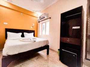 a bedroom with a bed with an orange wall at Hotel Candolim Aloft in Candolim
