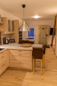 una cocina con armarios de madera, mesa y sillas en Hof Timmermann - Heuboden, en Ottenstein