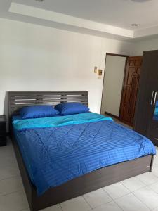 a bed in a bedroom with a blue comforter at TG2 - Tientong Guesthouse 2 in Hua Hin
