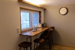 a kitchen with a bar with stools and a clock on the wall at Hof Timmermann - Spatzennest in Ottenstein