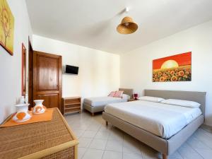 een slaapkamer met een bed, een bank en een tafel bij Antonella B&B in Leuca