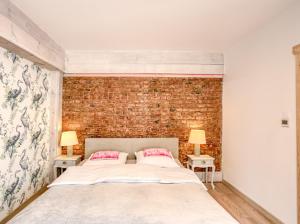 a bedroom with a large bed and a brick wall at Dom nad morzem Ludwikowo in Skrzeszewo