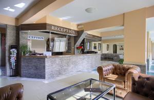 a lobby with leather furniture and a reception counter at Hotel Naslada in Balchik