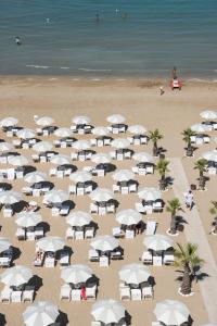 an overhead view of a beach with white umbrellas at Hotel Excelsior in Pesaro