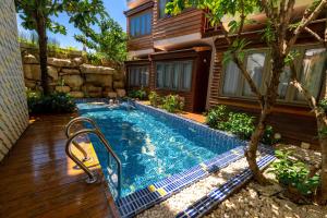 - une piscine en face d'une maison dans l'établissement Pastell Oldtown Chiang Mai SHA Extra Plus, à Chiang Mai