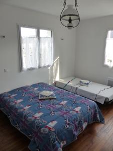 a bedroom with two beds in a room at LA MAISON BLEUE in Arzon