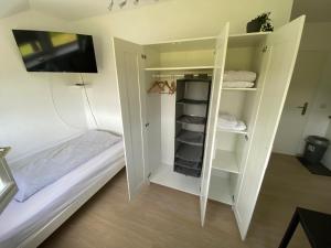 a room with a bed and a white closet at Etzel-Lodge Feldblick in Friedeburg