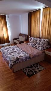 Pensiunea Dumbrăvița في Dumbrava: غرفة نوم بسرير كبير وأريكة