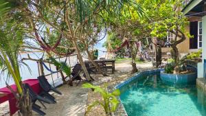 a pool with chairs and a picnic table and trees at Reggae Vibes De Romblon in Agpanabat