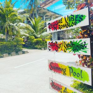 un panneau de rue avec graffiti devant une rue dans l'établissement Reggae Vibes De Romblon, à Agpanabat