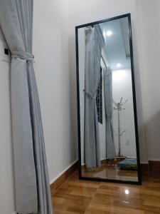 espejo con reflejo de una cortina en una habitación en BBNC Homestay, en Hoàng Mai