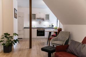 cocina y sala de estar con mesa y sillas en Ferienwohnungen Zum Hülsenbusch en Bispingen
