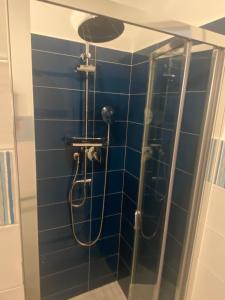 a shower in a bathroom with a blue tile wall at CasaLo in Trappitello