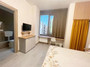 een hotelkamer met een slaapkamer met een bed en een televisie bij Sissi Comfort Rooms Foresteria Lombarda in Monza