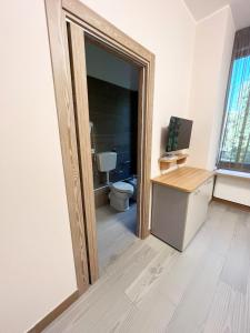 a bathroom with a toilet and a desk with a mirror at Sissi Comfort Rooms Foresteria Lombarda in Monza