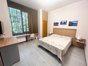 1 dormitorio con cama, escritorio y ventana en Sissi Comfort Rooms Foresteria Lombarda en Monza