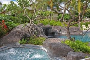 uma piscina com uma cascata num quintal em Palm Villas G1 32 em Waikoloa