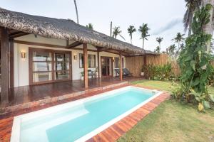 a villa with a swimming pool in front of a house at Rare Beachfront Villa - 2BR - 6 Pax Private Pool on Tuason Surf Spot in General Luna