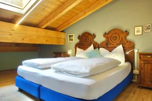 two twin beds in a room with wooden ceilings at Apartments DA LA VEDLA Flats in San Cassiano