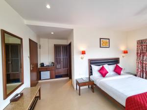 a bedroom with a large bed with red pillows at Bella Vista Mahabaleshwar in Mahabaleshwar