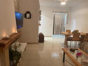 sala de estar con TV y comedor en Casa de playa, en Tarragona