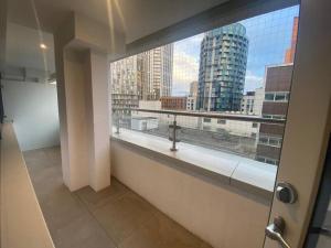 a bathroom with a large window with a view of a city at 90s RETRO 1Bed Studio Apartment Wembley Park London Private GYM & CINEMA & Netflix Perfect for Solo & Coupled Travellers in London