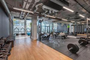 a gym with dumbbells and other equipment in a room at 90s RETRO 1Bed Studio Apartment Wembley Park London Private GYM & CINEMA & Netflix Perfect for Solo & Coupled Travellers in London