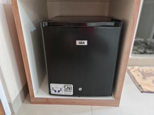 um frigorífico preto num canto de um quarto em 37 Guesthouse em Jakarta