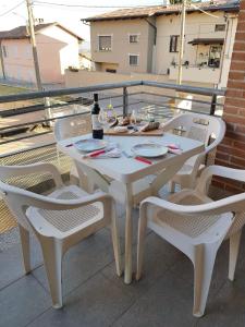 una mesa blanca y sillas con una botella de vino en Langhe e Roero - Casa da Angela, en Sommariva Perno