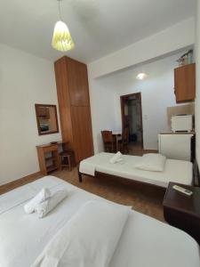 a hotel room with two beds and a kitchen at Chrysa's Studios in Loutra Edipsou