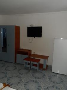 a room with a table and a tv on a wall at Vila Margaritar in Eforie Sud