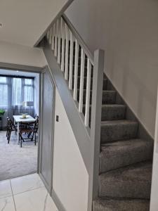 a staircase leading to a living room with a table at Remarkable 3-Bed Apartment in London in London