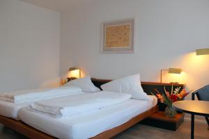 um quarto com 2 camas e uma mesa em Hotel Lamm em Nufringen