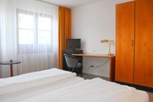 um quarto de hotel com duas camas e uma secretária com um computador em Hotel Lamm em Nufringen