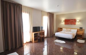 Habitación de hotel con cama y TV en HOTEL MARIA ROSA en Pedrola