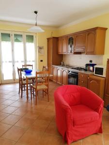 een keuken met een tafel en een rode stoel bij Langhe e Roero - Casa da Angela in Sommariva Perno