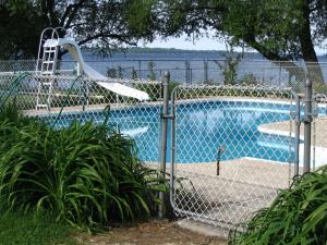 a swimming pool with a slide next to a fence at Hostellerie du Suroît in Beauharnois