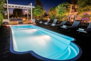 a swimming pool at night with chairs around it at Austeria Kazimierska in Kazimierz Dolny