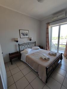 a bedroom with a bed with towels on it at Hotel Villa Mantalena in Alikanas