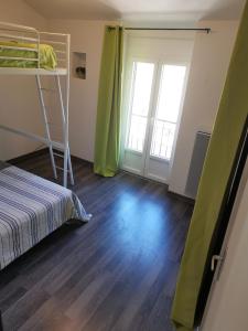 Superbe maison de village في Sourribes: غرفة نوم مع سرير بطابقين وأرضية خشبية