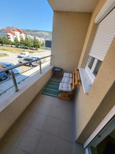 a balcony with a chair and a window and a street at Apartman Pati in Livno
