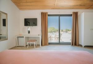 a bedroom with a bed and a window with a view at Ali Baba Ciftligi Boutique Hotel in Alaçatı