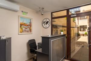 ein Büro mit Schreibtisch und Wanduhr in der Unterkunft Casa 86 in Bukarest