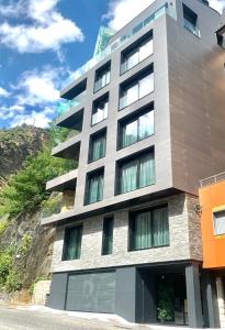 a tall building with windows on the side of a hill at Apartaments Turístics Conseller in Andorra la Vella
