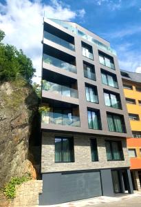 um edifício alto com janelas do lado de um penhasco em Apartaments Turístics Conseller em Andorra-a-Velha