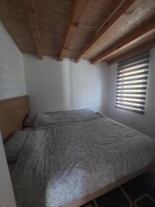 Bett in einem Zimmer mit Fenster in der Unterkunft Village House Gradac in Šavnik