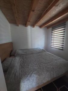 a bed in a room with a window at Village House Gradac in Šavnik