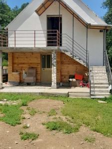 een huis met een veranda en een trap ervoor bij Village House Gradac in Šavnik
